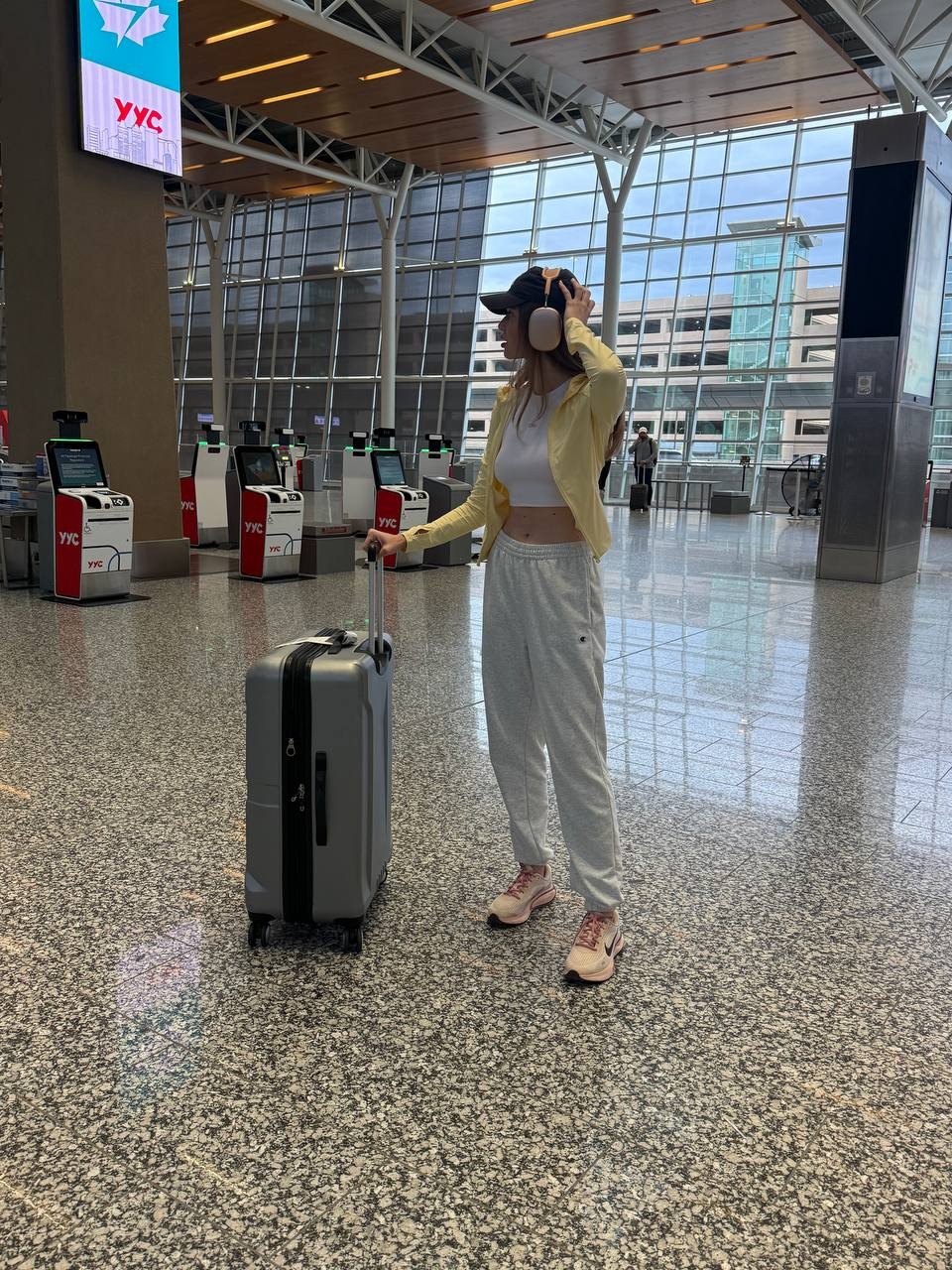 Sia with a suitcase in an airport hall